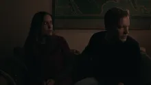 Two people sitting down, one looking away from the other